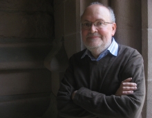 Leonard Barkan with arms crossed in an archway